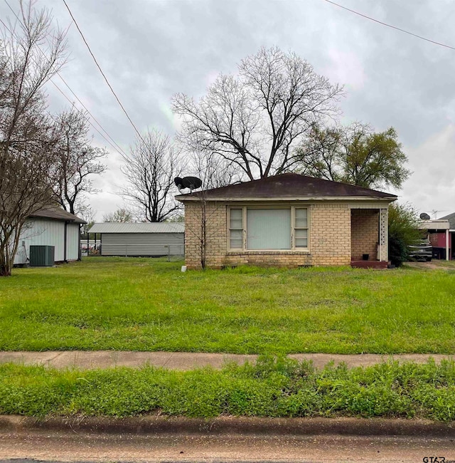 view of front of property with central air condition unit and a front yard