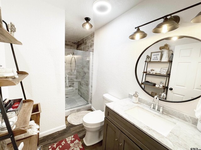 902 S Florey, Mount Pleasant, TX 75455 - bathroom featuring a stall shower, vanity, toilet, wood finished floors, and baseboards