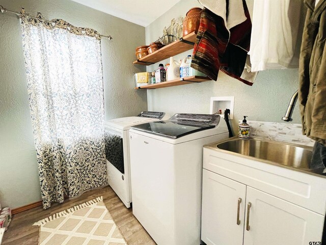 902 S Florey, Mount Pleasant, TX 75455 - laundry room featuring separate washer and dryer, a textured wall, light wood-style flooring, and cabinet space