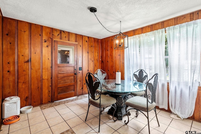 902 S Florey, Mount Pleasant, TX 75455 - dining space featuring a textured ceiling, wood walls, and a chandelier
