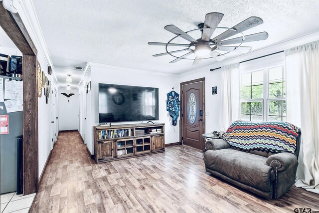 902 S Florey, Mount Pleasant, TX 75455 - living area with crown molding, ceiling fan, a textured ceiling, light wood-style floors, and baseboards