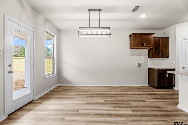 unfurnished dining area featuring light wood-type flooring