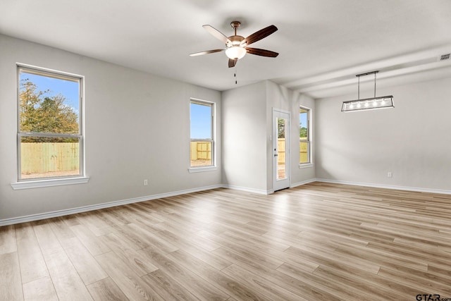 spare room with ceiling fan, a healthy amount of sunlight, and light hardwood / wood-style floors