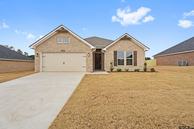 view of front of home with a front yard, a garage, and central AC unit