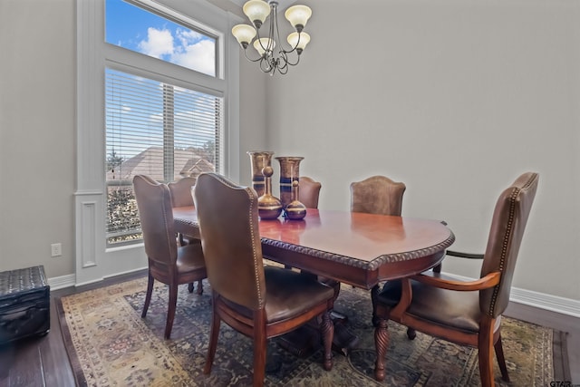 dining area featuring baseboards, wood finished floors, and a chandelier