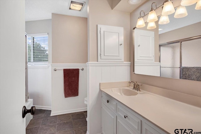 2733 Rockbridge Rd, Tyler, TX 75701 - full bath featuring vanity, a wainscoted wall, a shower with shower door, and a decorative wall