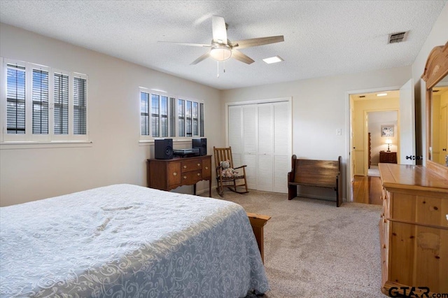 2733 Rockbridge Rd, Tyler, TX 75701 - bedroom with light colored carpet, a closet, a textured ceiling, and a ceiling fan
