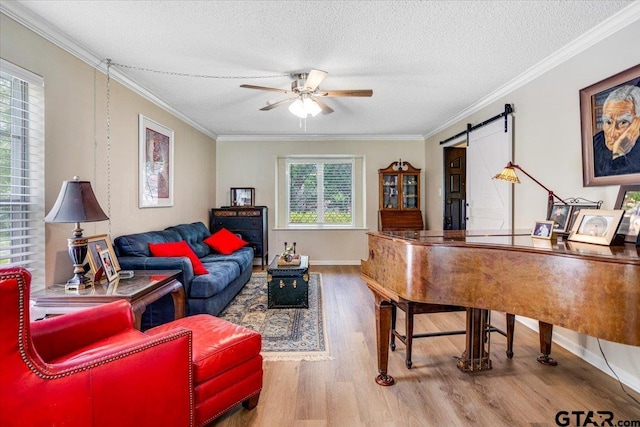2733 Rockbridge Rd, Tyler, TX 75701 - living area with a barn door, wood finished floors, a ceiling fan, a textured ceiling, and crown molding