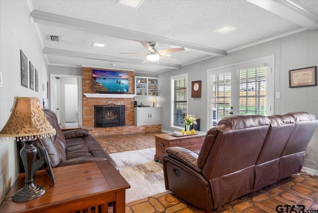 2733 Rockbridge Rd, Tyler, TX 75701 - living room featuring a textured ceiling, beamed ceiling, a fireplace, ceiling fan, and built in shelves