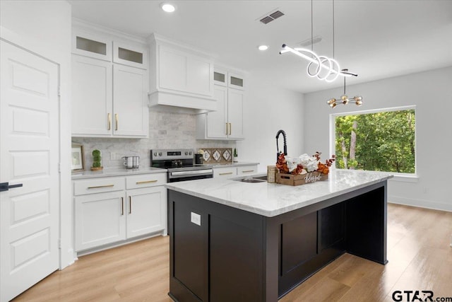 2099 Jackie Ave, Tyler, TX 75703 - kitchen with stainless steel electric range oven, a kitchen island with sink, decorative backsplash, white cabinetry, and recessed lighting