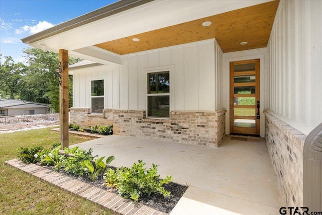 2099 Jackie Ave, Tyler, TX 75703 - doorway to property with board and batten siding, a patio, and brick siding