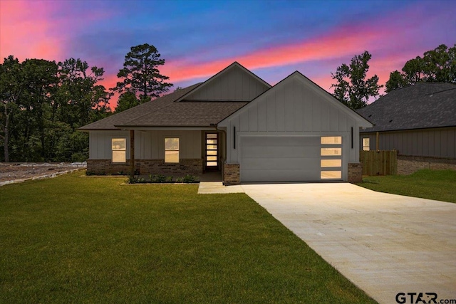 2099 Jackie Ave, Tyler, TX 75703 - view of front facade featuring an attached garage, a lawn, concrete driveway, and board and batten siding