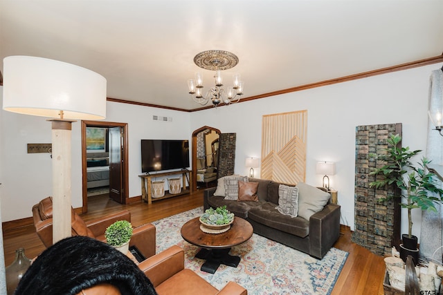 living room with visible vents, a notable chandelier, wood finished floors, arched walkways, and crown molding