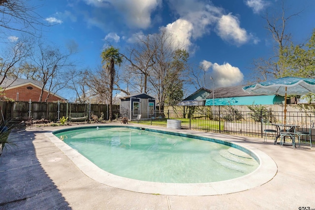 view of pool featuring a patio, an outdoor structure, and a fenced backyard