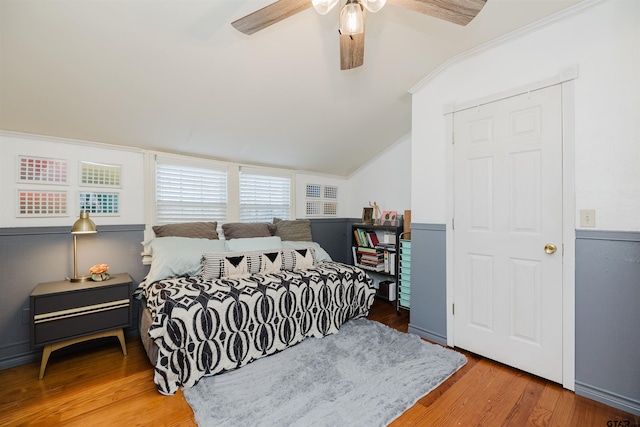 bedroom with vaulted ceiling, ceiling fan, and wood finished floors