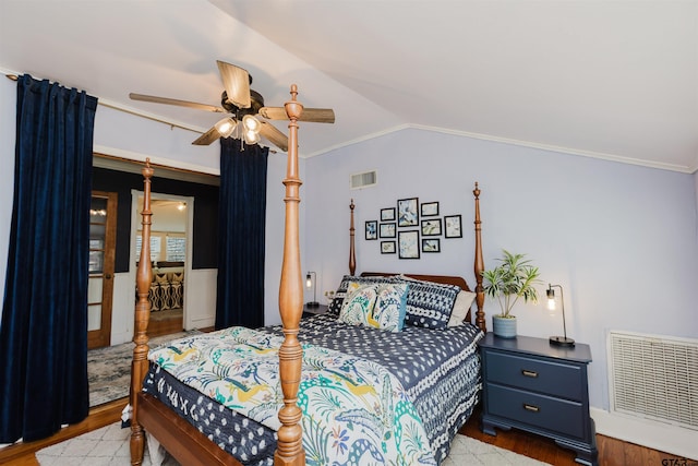 bedroom featuring lofted ceiling, crown molding, wood finished floors, and visible vents