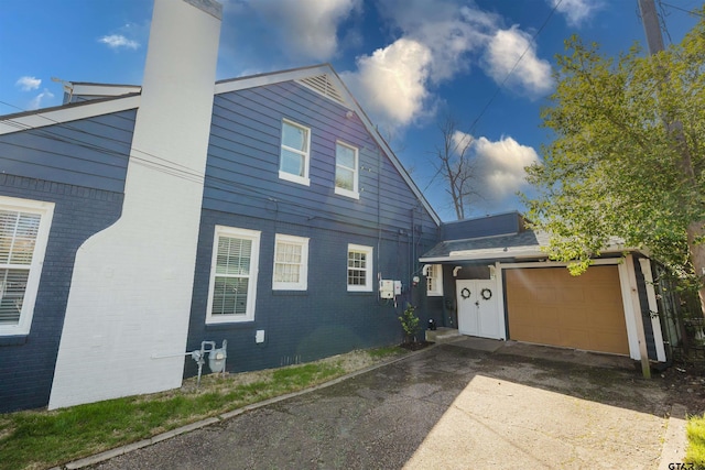 view of front facade featuring a garage, brick siding, and concrete driveway