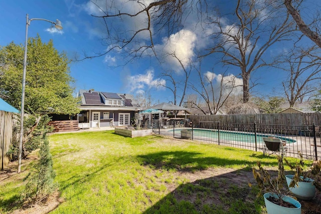 view of yard with a fenced in pool, french doors, a fenced backyard, and a patio