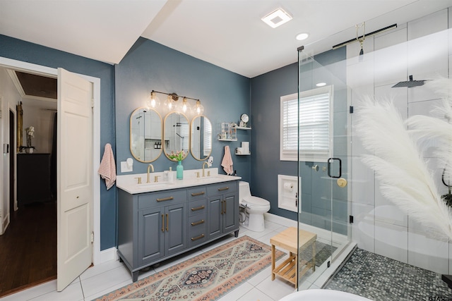 bathroom featuring tile patterned flooring, a stall shower, toilet, and a sink