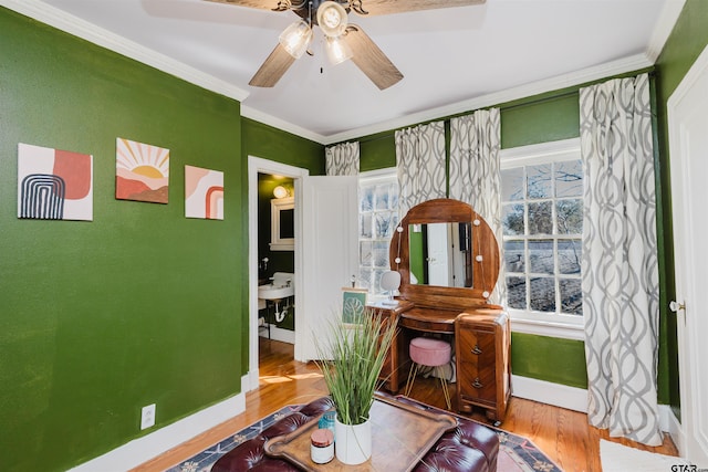 sitting room with ceiling fan, baseboards, wood finished floors, and ornamental molding