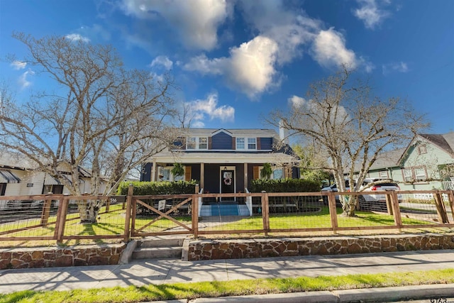 view of front of house with a fenced front yard, covered porch, a front yard, and a gate