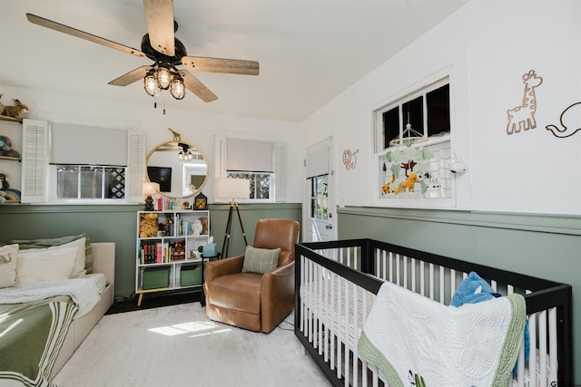 bedroom featuring a crib and ceiling fan