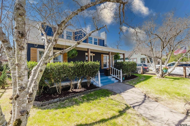 view of front of property featuring a porch, a front yard, and a chimney