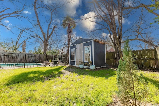 view of yard with an outbuilding, a fenced in pool, and a fenced backyard