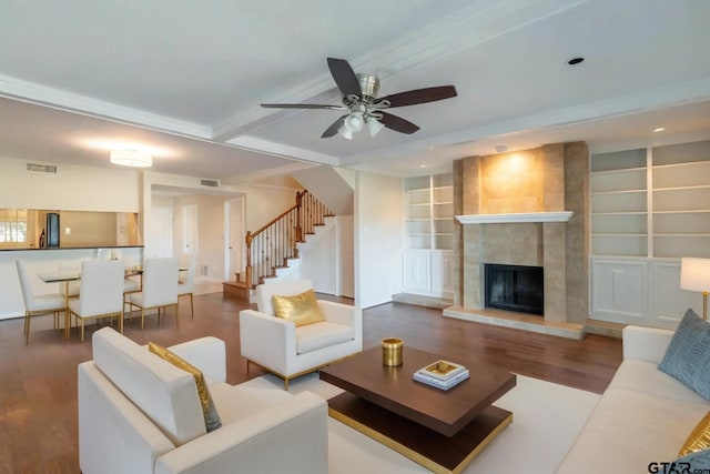 living room with stairs, wood finished floors, visible vents, and a fireplace