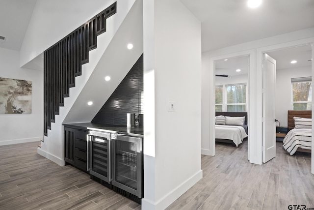 331 W Eagle Pt, Mount Vernon, TX 75457 - bar featuring baseboards, stairs, light wood-style flooring, and beverage cooler