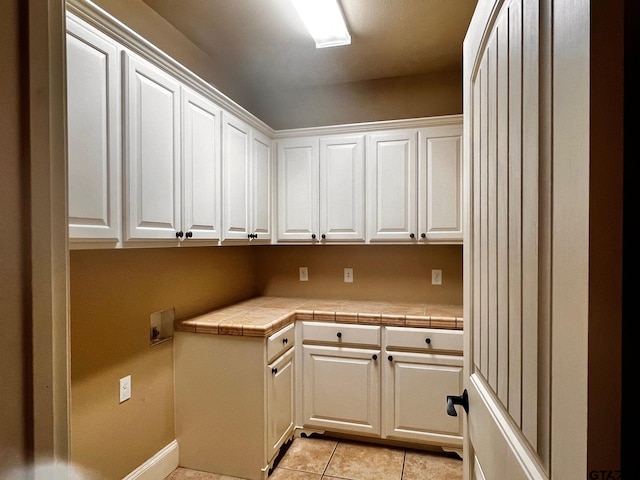 washroom with cabinets and light tile patterned flooring