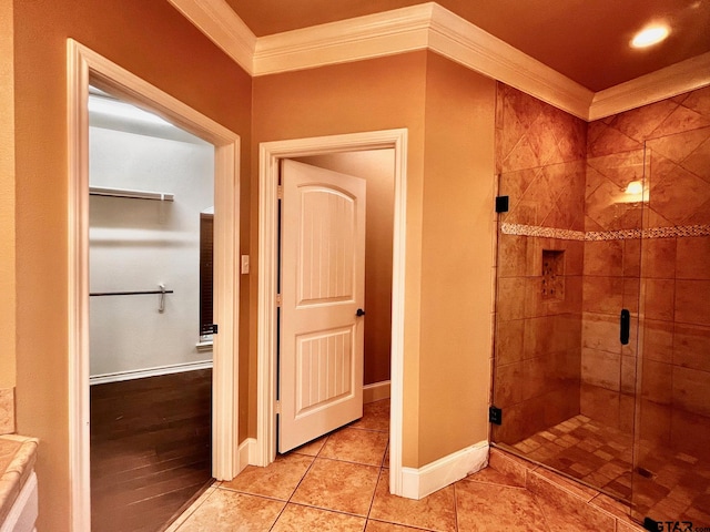 bathroom with wood-type flooring, a shower with door, and crown molding