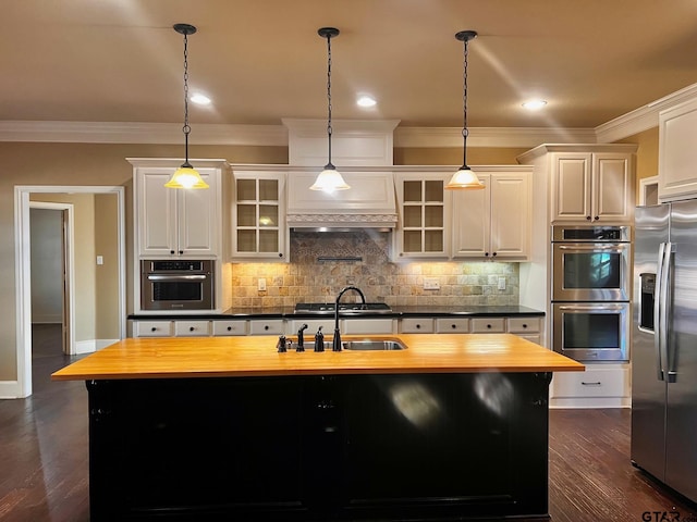 kitchen featuring white cabinetry, stainless steel appliances, and butcher block countertops