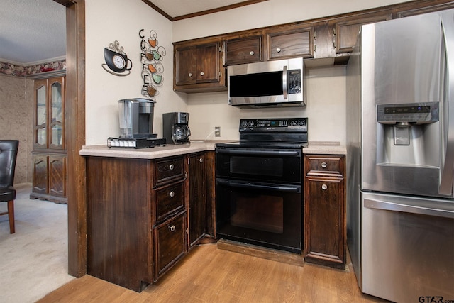 10187 Crestview Dr, Tyler, TX 75707 - kitchen with stainless steel appliances, crown molding, light countertops, dark brown cabinetry, and light wood-style floors