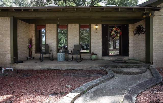 10187 Crestview Dr, Tyler, TX 75707 - doorway to property with covered porch and brick siding