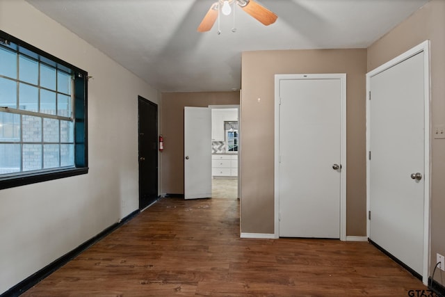 corridor featuring baseboards and wood finished floors