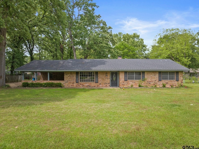 ranch-style house with brick siding, fence, and a front lawn