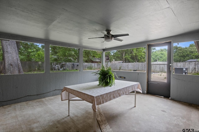 sunroom with concrete flooring and a ceiling fan