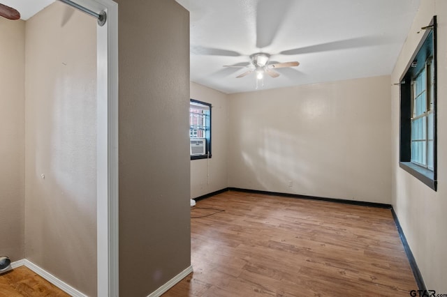 empty room with baseboards, a ceiling fan, and wood finished floors