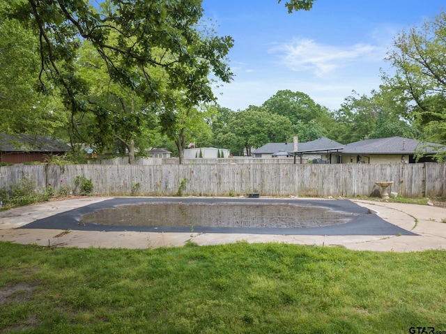 view of swimming pool featuring a lawn and a fenced backyard