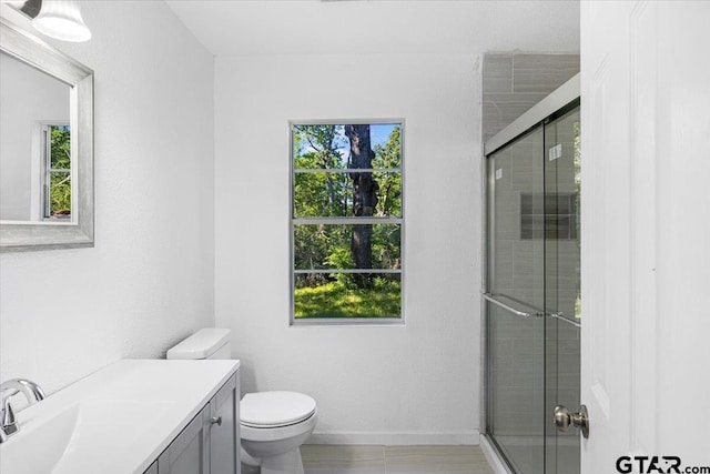 full bath with baseboards, a shower stall, toilet, and vanity