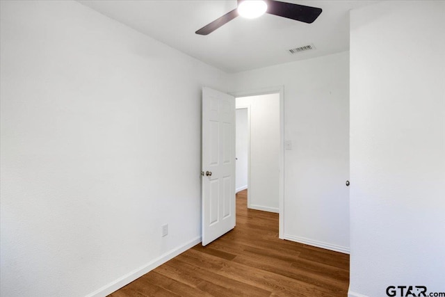 unfurnished bedroom featuring baseboards, wood finished floors, visible vents, and a ceiling fan