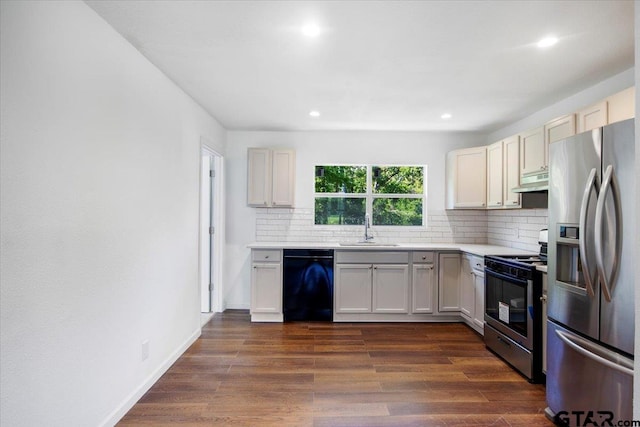 kitchen with under cabinet range hood, backsplash, light countertops, a sink, and appliances with stainless steel finishes