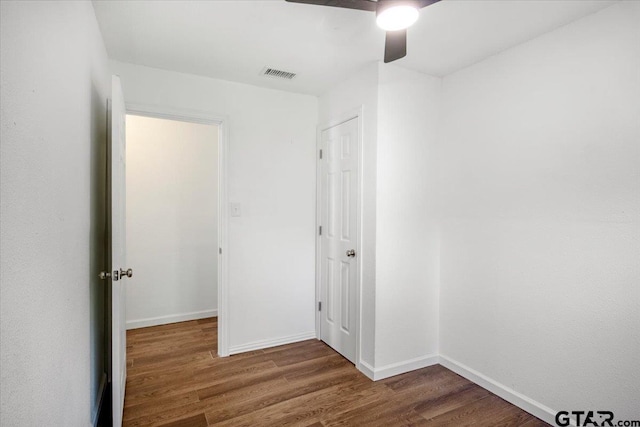 unfurnished bedroom featuring baseboards, wood finished floors, visible vents, and a ceiling fan
