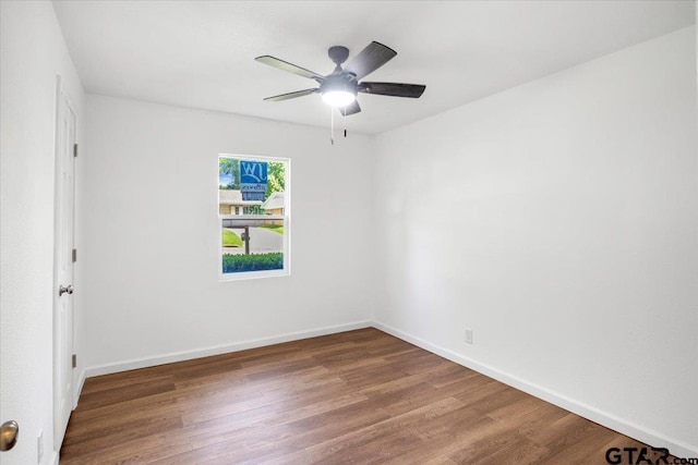 empty room with baseboards, a ceiling fan, and wood finished floors