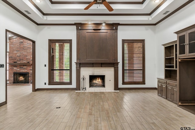 unfurnished living room with light wood-type flooring, a large fireplace, and crown molding