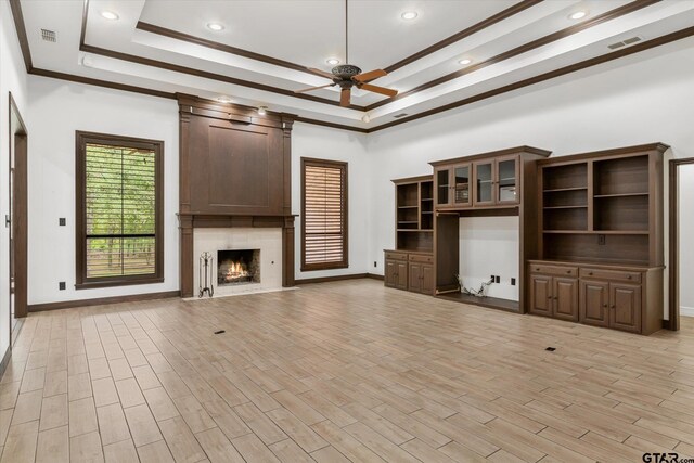 4601 Dickens, Athens, TX 75751 - unfurnished living room with ceiling fan, a tray ceiling, light wood-style floors, a high end fireplace, and ornamental molding