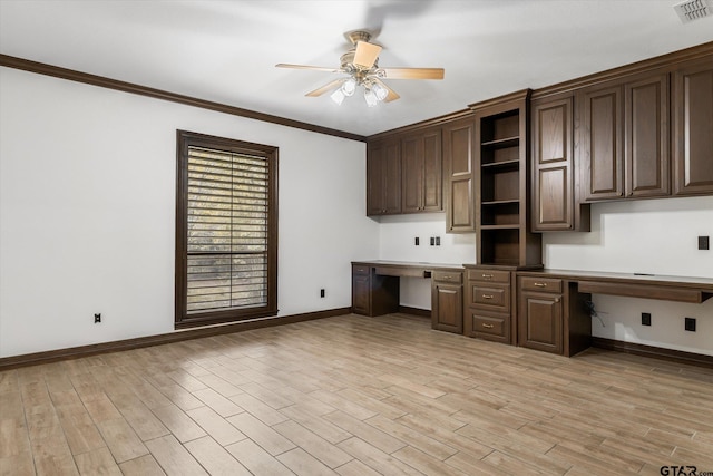 unfurnished office featuring ceiling fan, built in desk, crown molding, and light hardwood / wood-style flooring