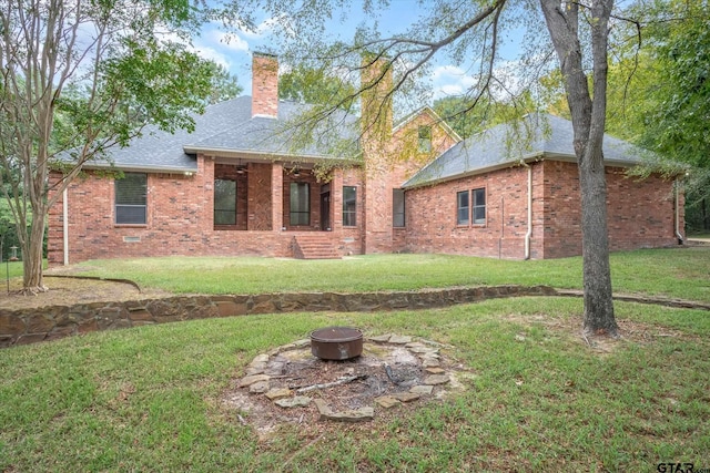 4601 Dickens, Athens, TX 75751 - back of house featuring an outdoor fire pit, brick siding, a chimney, and a lawn