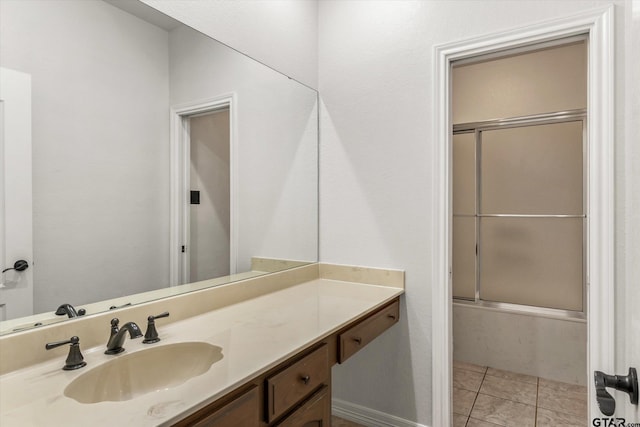 bathroom featuring enclosed tub / shower combo, tile patterned flooring, and vanity